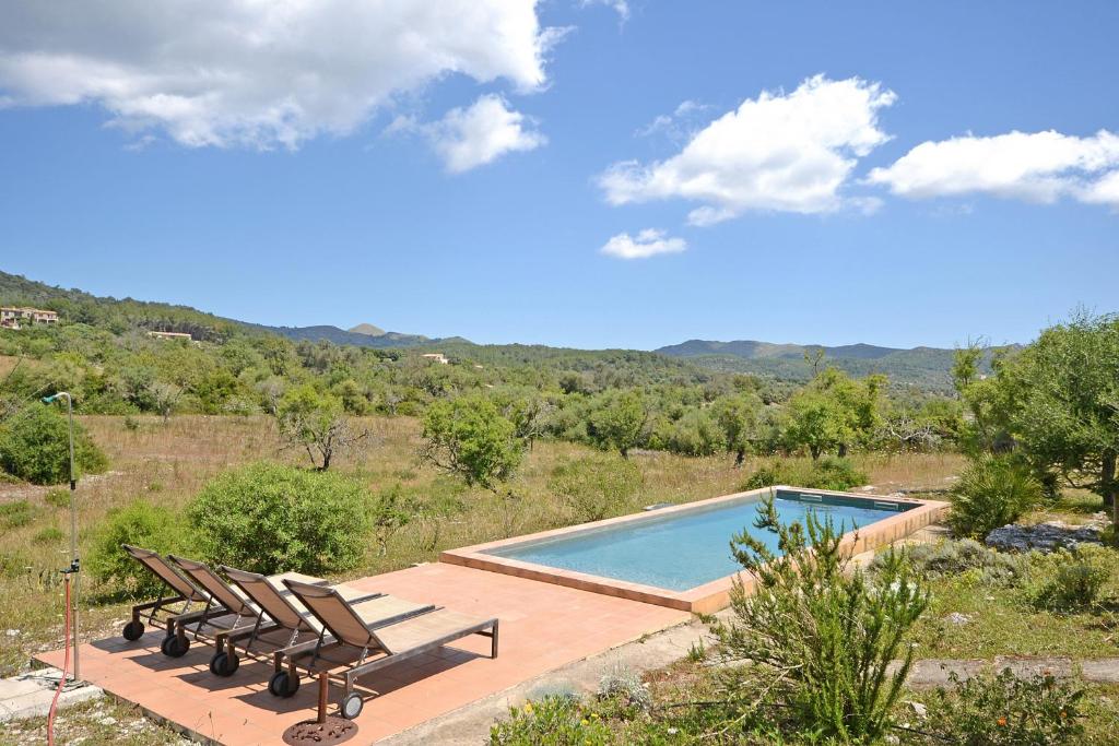 a swimming pool with two lounge chairs next to it at Villa Font in Artá