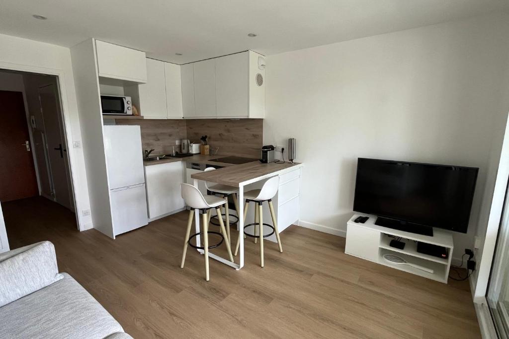 a small kitchen with a table and a television at Studio with balcony and pool in La Baule in La Baule