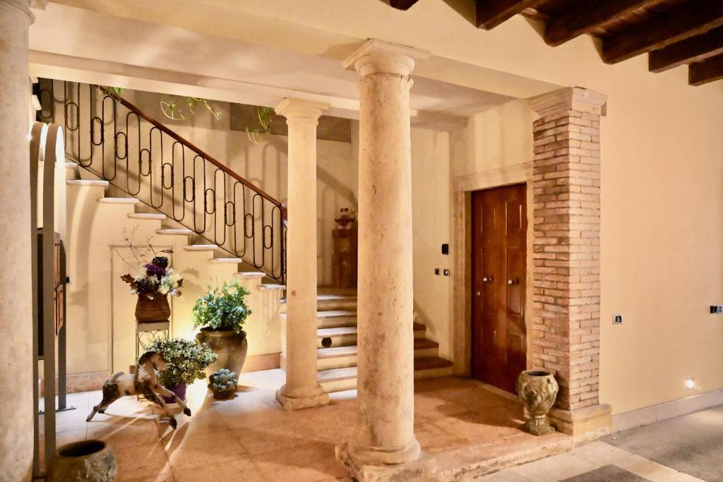 a hallway with columns and a staircase in a house at Palazzo Cavalli Pasquini in Verona