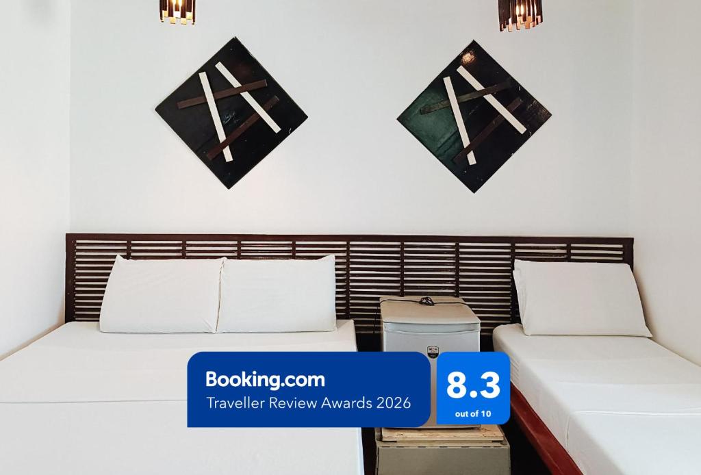 a bedroom with two beds and a sign on the wall at Hotel Elinas and Restaurant in Tuguegarao City