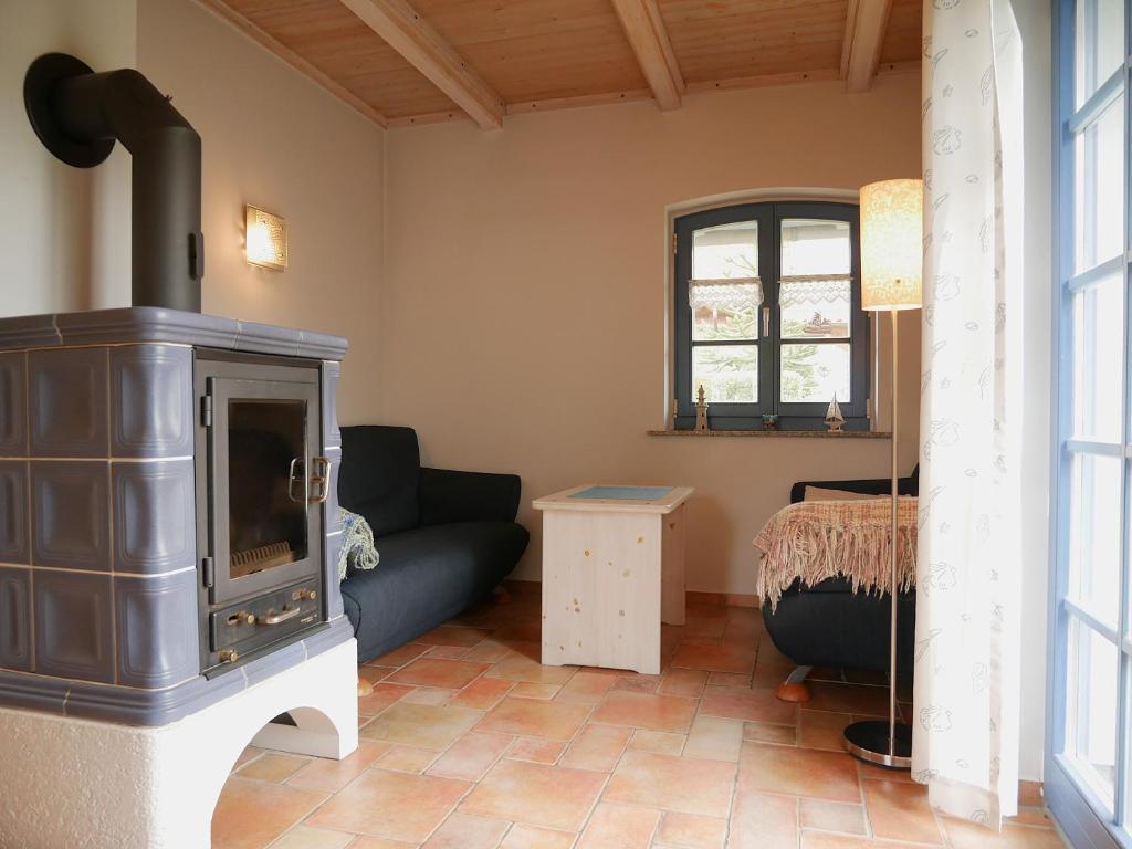 a living room with a stove and a couch at Poeler Inselhaus in Kaltenhof