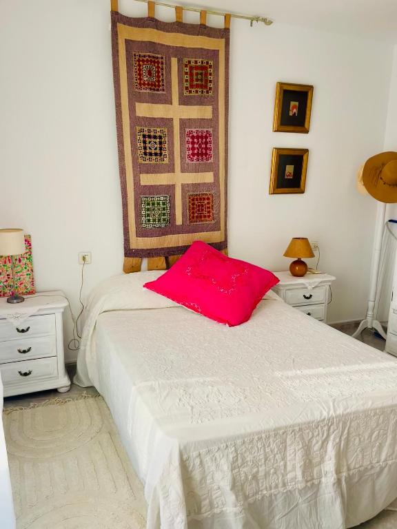 a bedroom with a bed with a red pillow on it at Lydia Cabo Cope in Calabardina