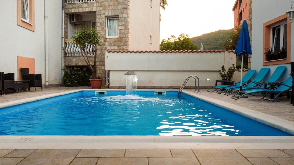 a swimming pool with a fountain in a building at Villa Ipera in Budva