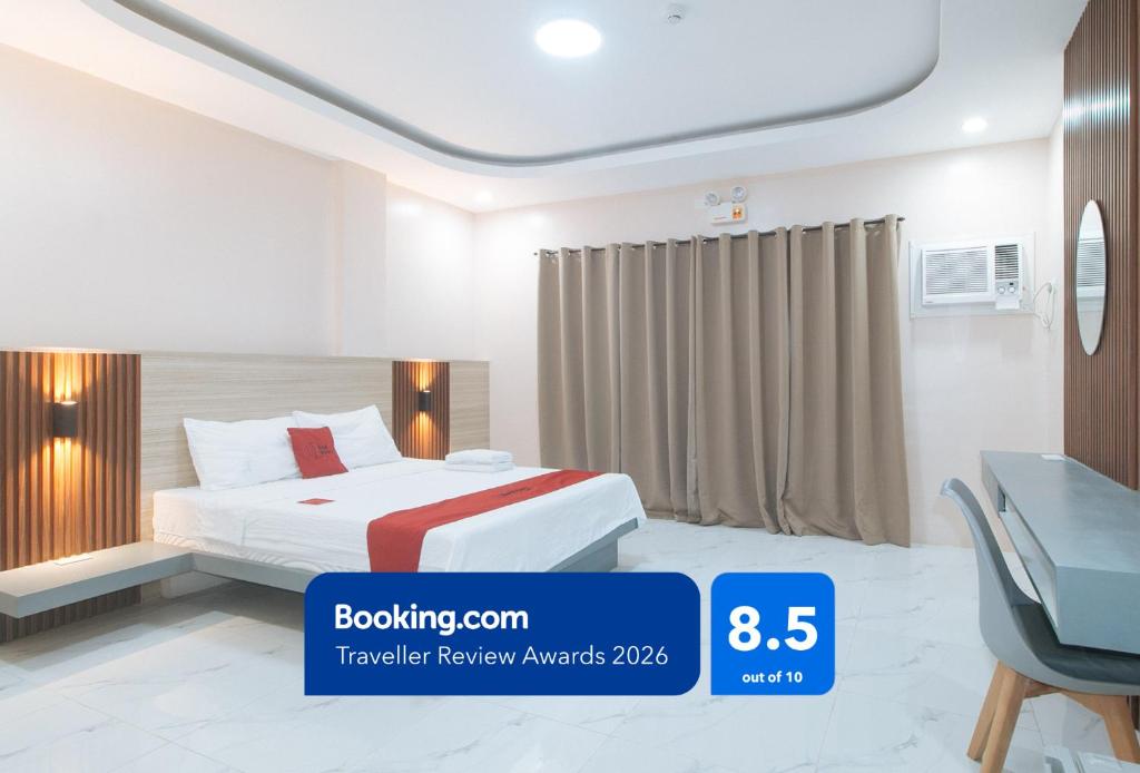 a hotel room with a bed and a desk at RedDoorz at Happy Stay Apartelle in Dauis