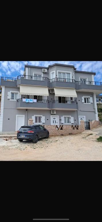 a car parked in front of a large building at Vila shabani in Sarandë