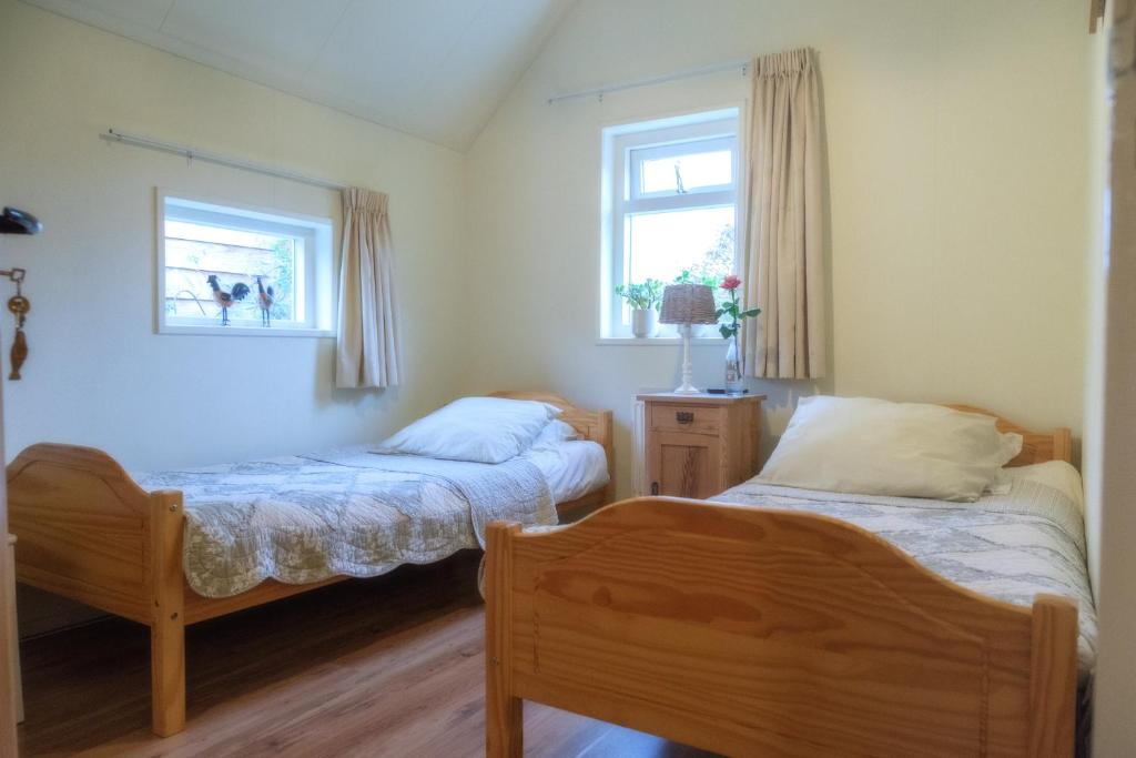 a bedroom with two beds and a window at Oes-Tilber in Zweeloo