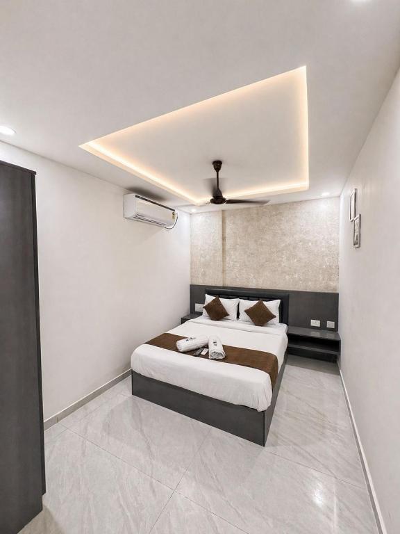 a bedroom with a large bed with a ceiling at Hotel Lime Wood Mangaluru in Mangalore