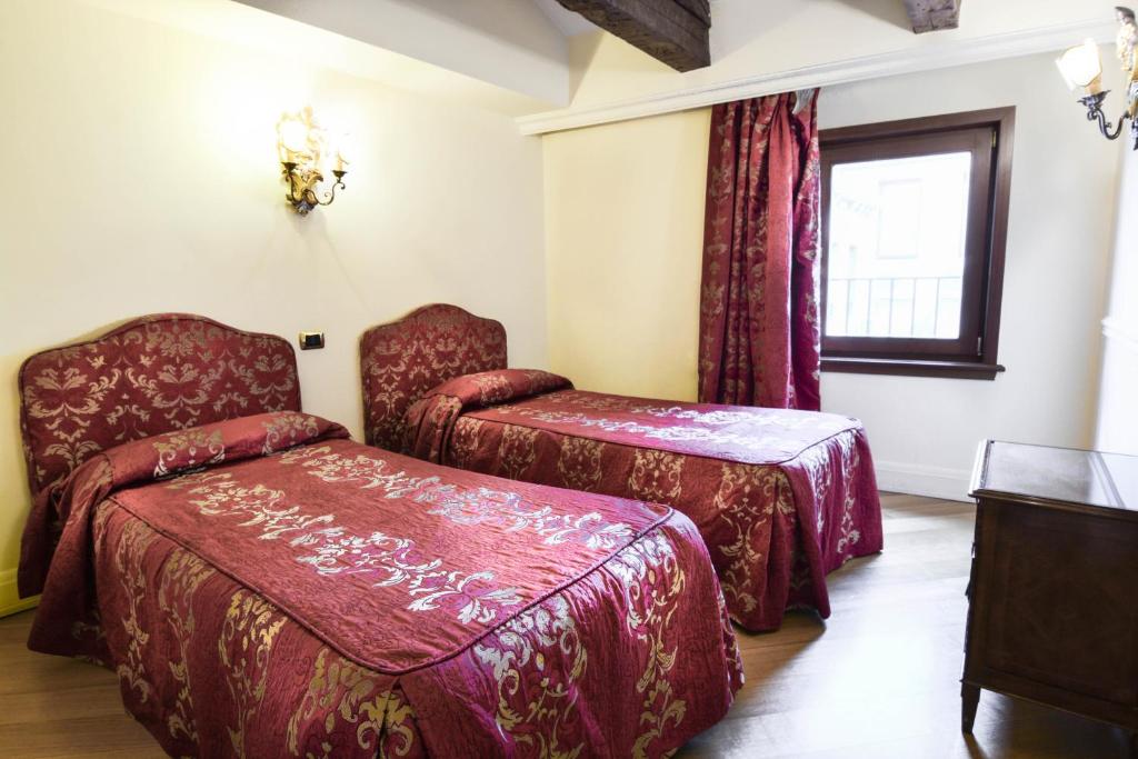 Postel nebo postele na pokoji v ubytování Suites Torre Dell'Orologio
