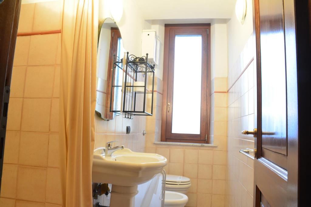 łazienka z umywalką, toaletą i oknem w obiekcie Villa Regina w Amelii