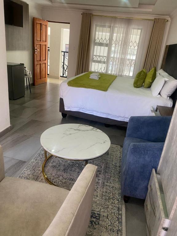 a hotel room with two beds and a couch at Hotel El Infinito in Kempton Park