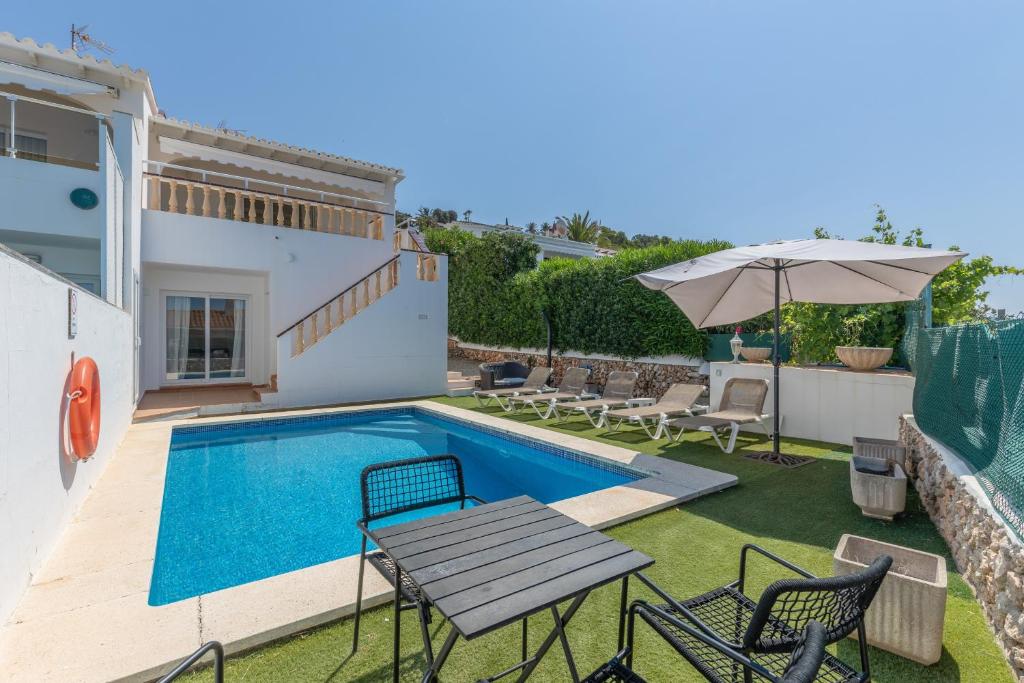 a pool with a table and chairs and an umbrella at Villa Sea Lights 89b in Son Bou