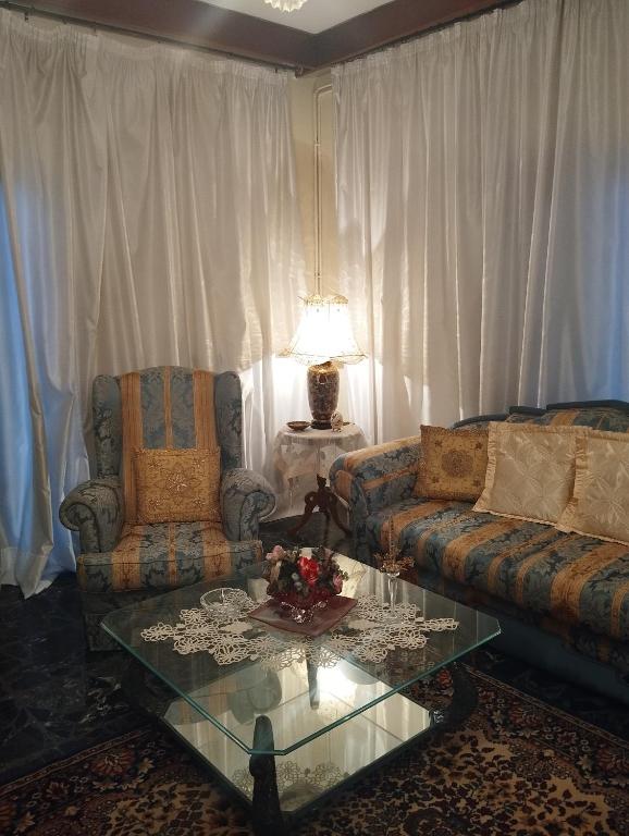 a living room with two couches and a glass table at Fiorela Gest House in Kalabaka