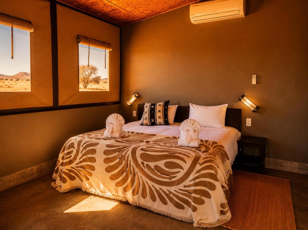 a bedroom with a bed in a room with windows at Soft Adventure Camp in Solitaire