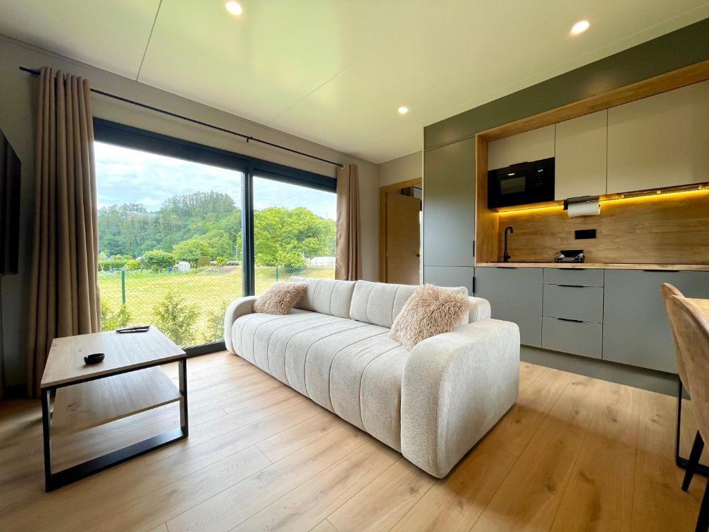 a living room with a white couch and a large window at LA TIERRUCA HOMES in Barcenaciones