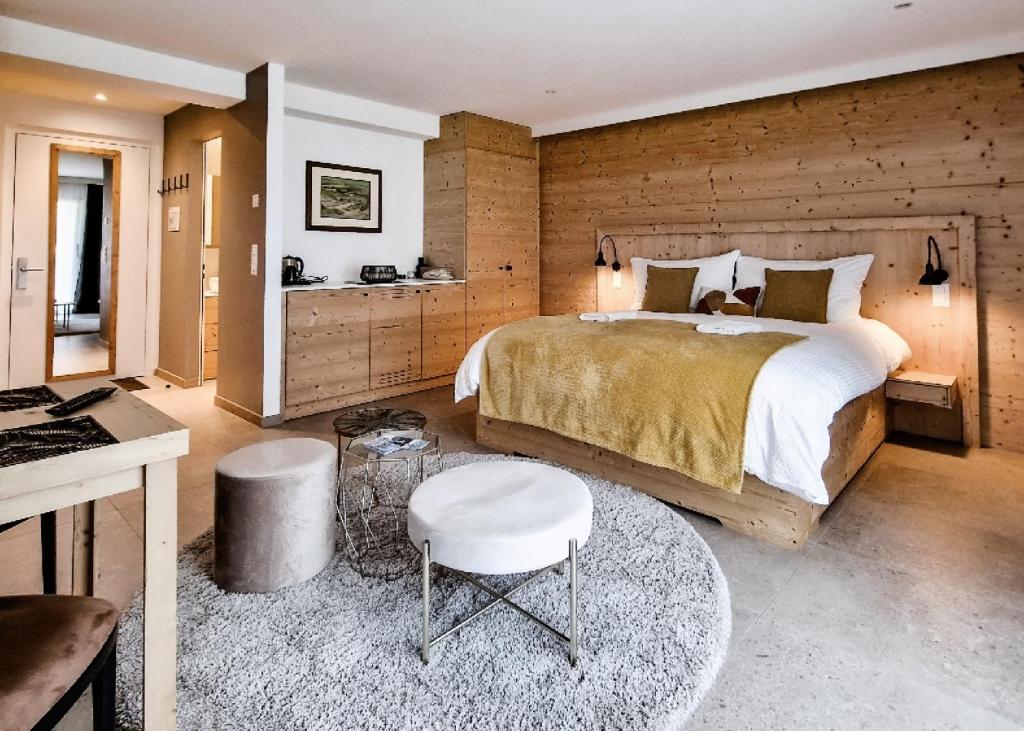 ein Schlafzimmer mit einem großen Bett und einer Holzwand in der Unterkunft John's Lodge in Les Collons