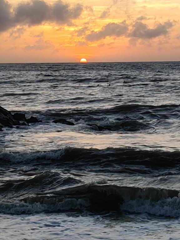 a sunset over a body of water with waves at Scoop Cabana Kitesurfing in Kalpitiya