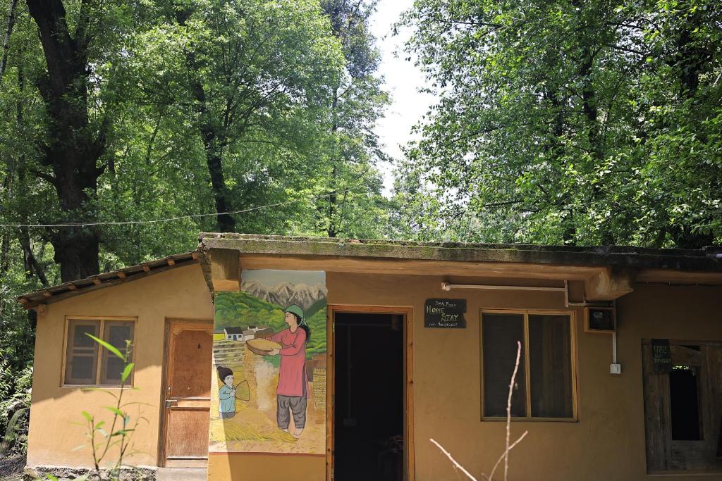a house with a painting on the side of it at NotOnMap- Saal River Homestay in Chamba