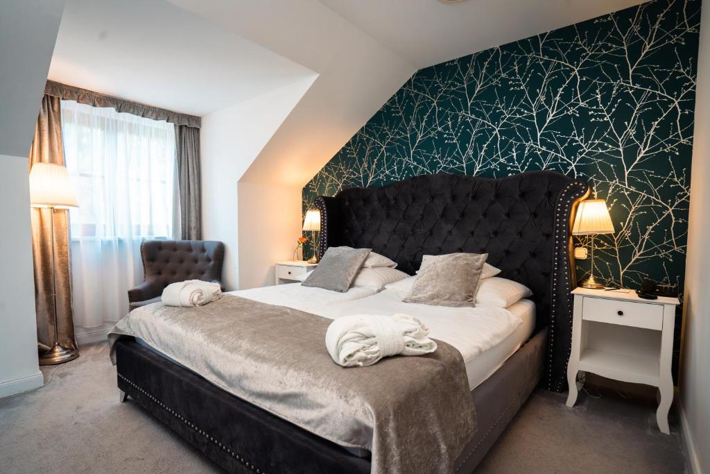 a bedroom with a large bed with towels on it at Bodrogi Kúria Wellness Hotel in Inárcs