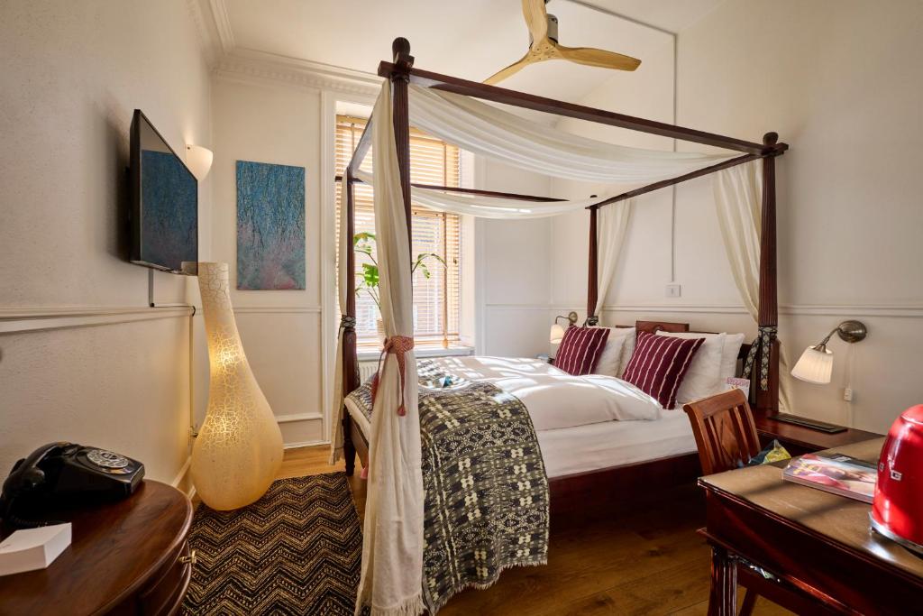 a bedroom with a canopy bed and a desk at 66 Guldsmeden in Copenhagen