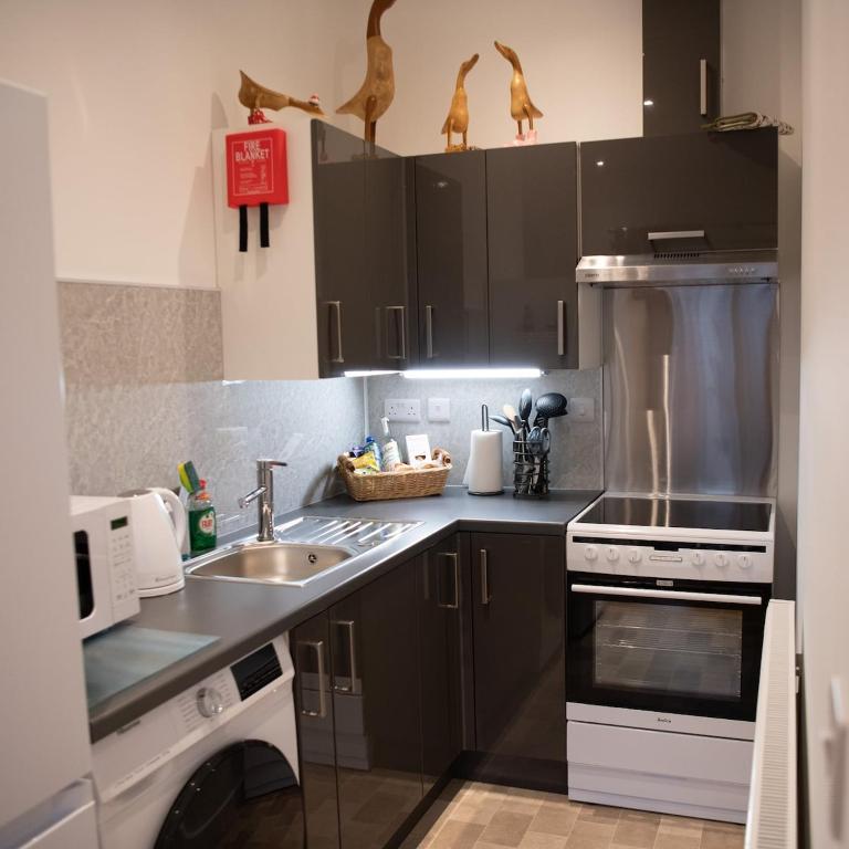 a kitchen with a sink and a stove top oven at Stylish Apartment Coppcliffe Grantham in Grantham