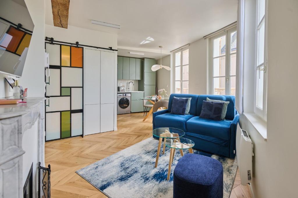 ein Wohnzimmer mit einem blauen Sofa und einem Tisch in der Unterkunft C'Châtelet in Chartres
