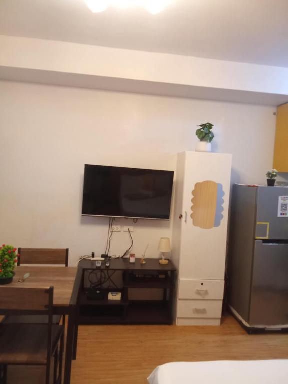 a living room with a flat screen tv and a table at Lois Ann Condo in Pontud