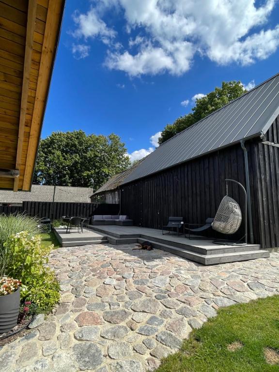 a backyard with a building with a stone patio at Slow Home in Dziemiany