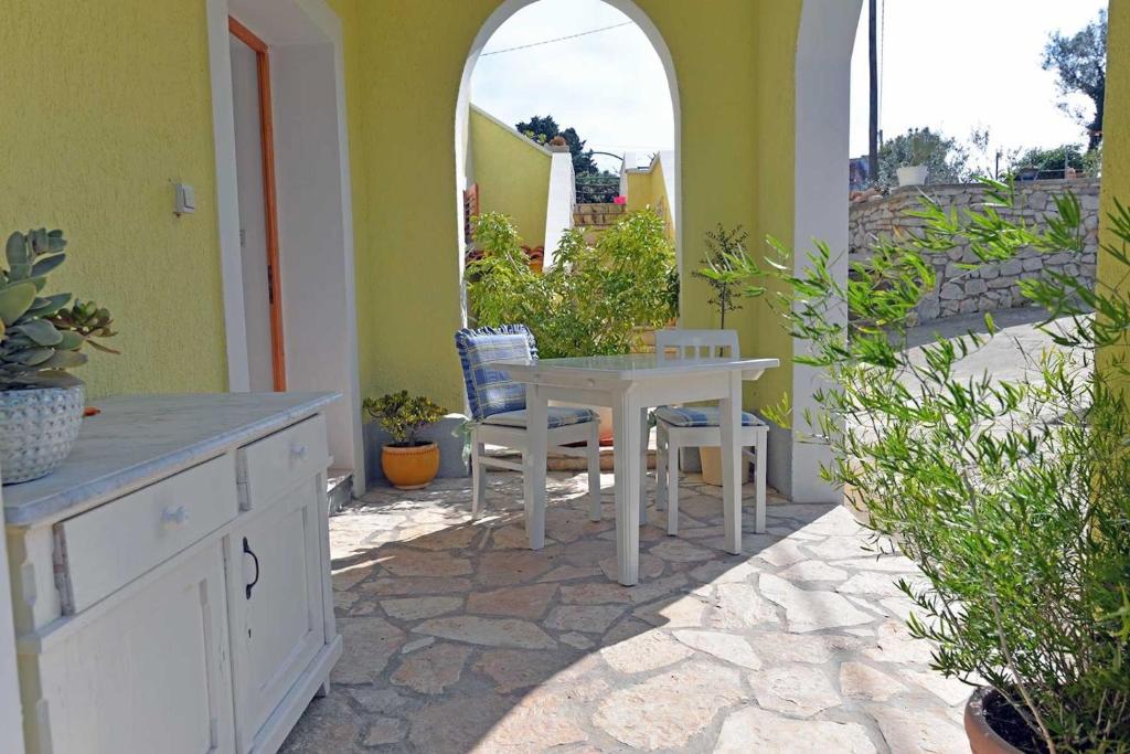 un patio con tavolo e sedie su un patio di Roberto Apartments a Veli Lošinj (Lussingrande)