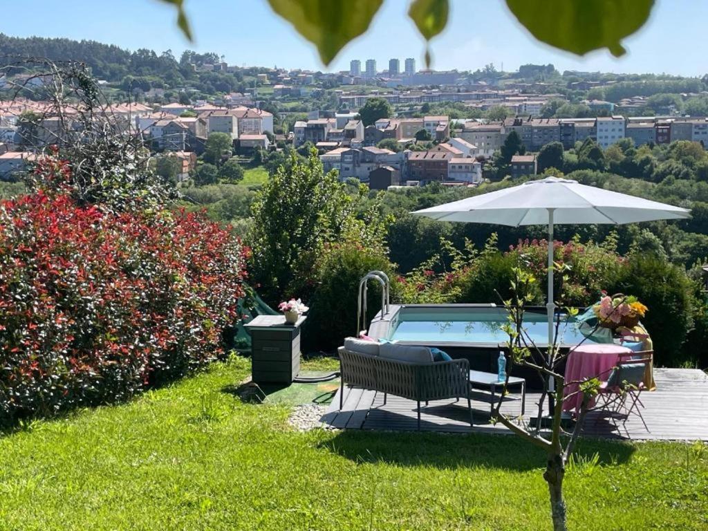 a bench and an umbrella next to a pool at Gloria's Design House in Santiago de Compostela