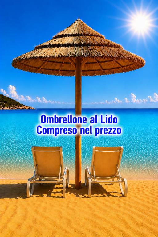 two chairs under an umbrella on a beach at La Perla dell' Adriatico Apartments - Perla Aurea - in Termoli