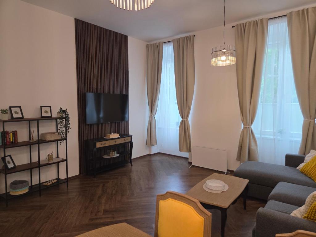 a living room with a couch and a tv at Apartmán Square Lipno in Horní Planá