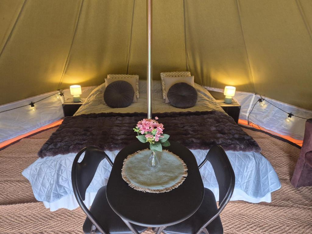 a bedroom with a bed with a table and flowers at Odenlunds glamping in Sparrarp
