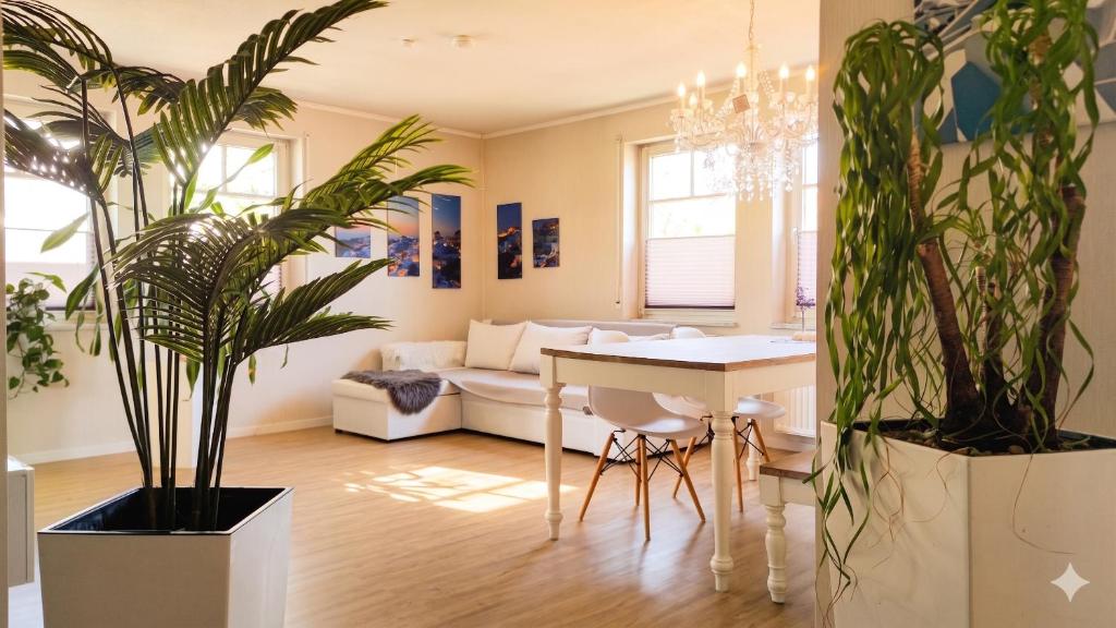 a living room with plants and a table and a couch at Lake FeWo Santorini in Oberteuringen