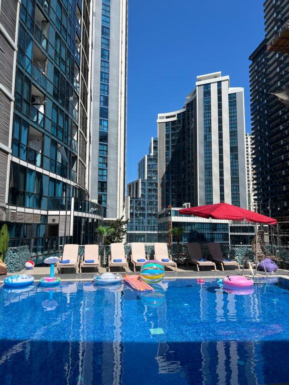 a large pool with chairs and frisbees in a city at New Wave Hotel in Batumi