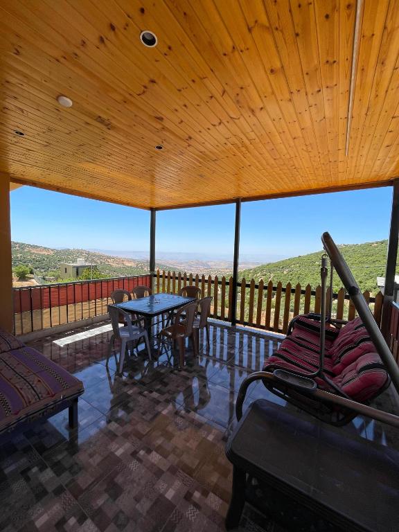 a large screened in porch with a table and chairs at Alreem Farm in Ajloun