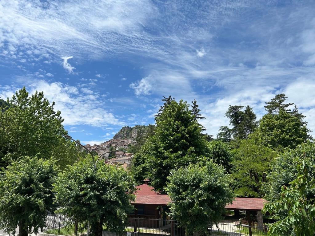 a house with trees and a blue sky with clouds at LB Guest House in Tagliacozzo