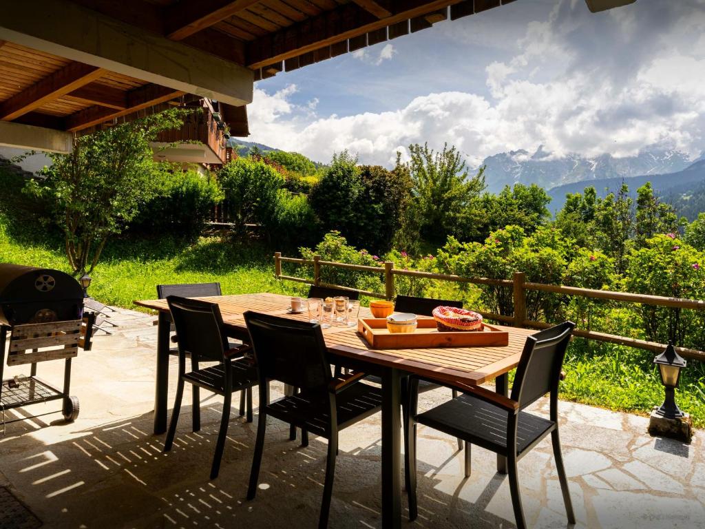 a wooden table and chairs on a patio at Chalet Aravista - OVO Network in Le Grand-Bornand