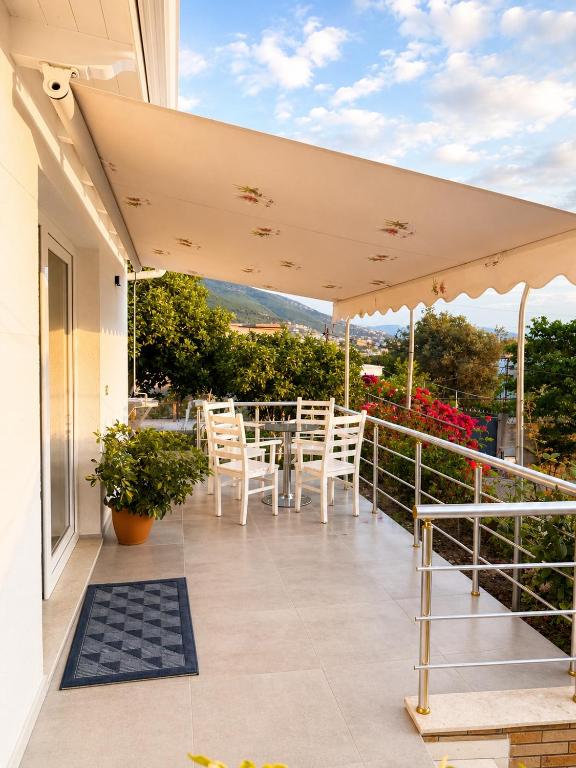a patio with a table and chairs on a balcony at Deon in Vlorë