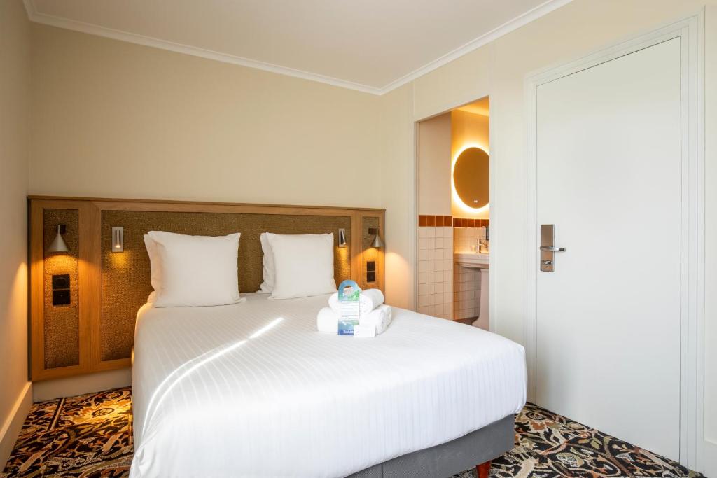 a hotel room with a large white bed in a room at Best Western Hotel Centre Reims in Reims