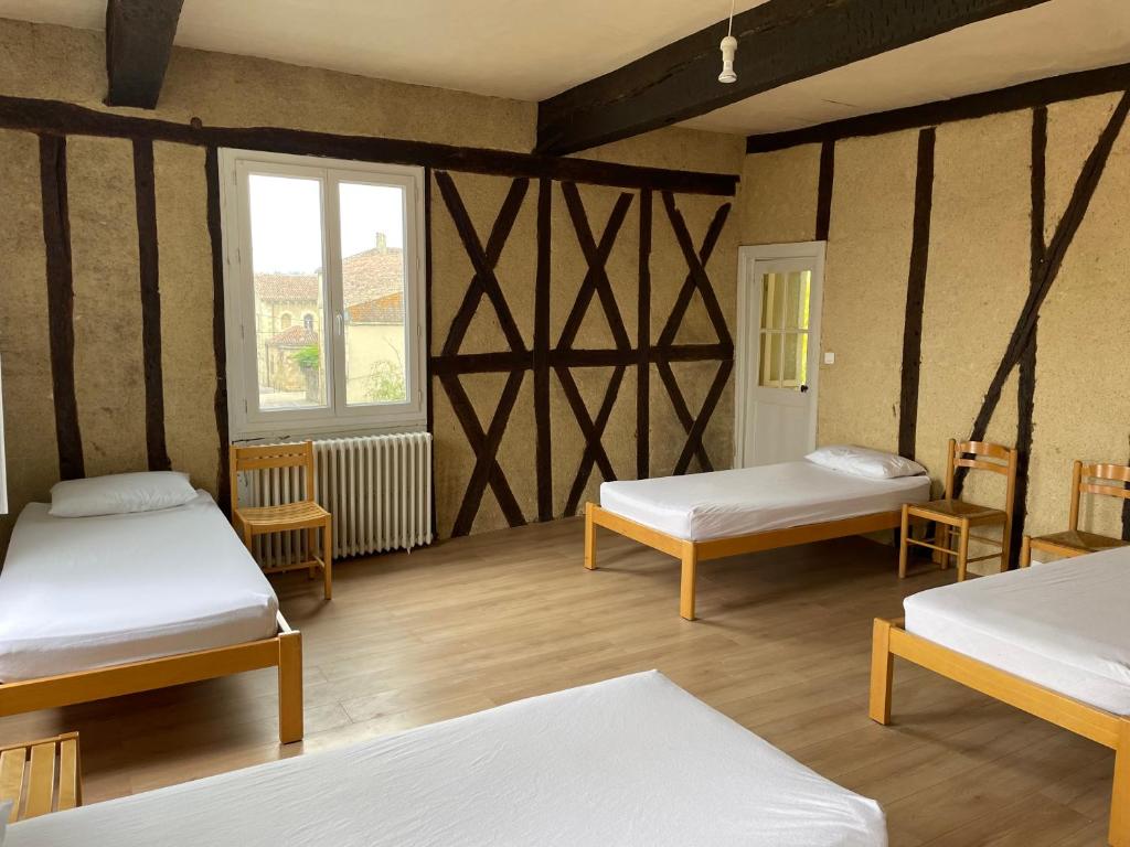 a room with three beds and a window at Gîte de la cathédrale 2 in Condom