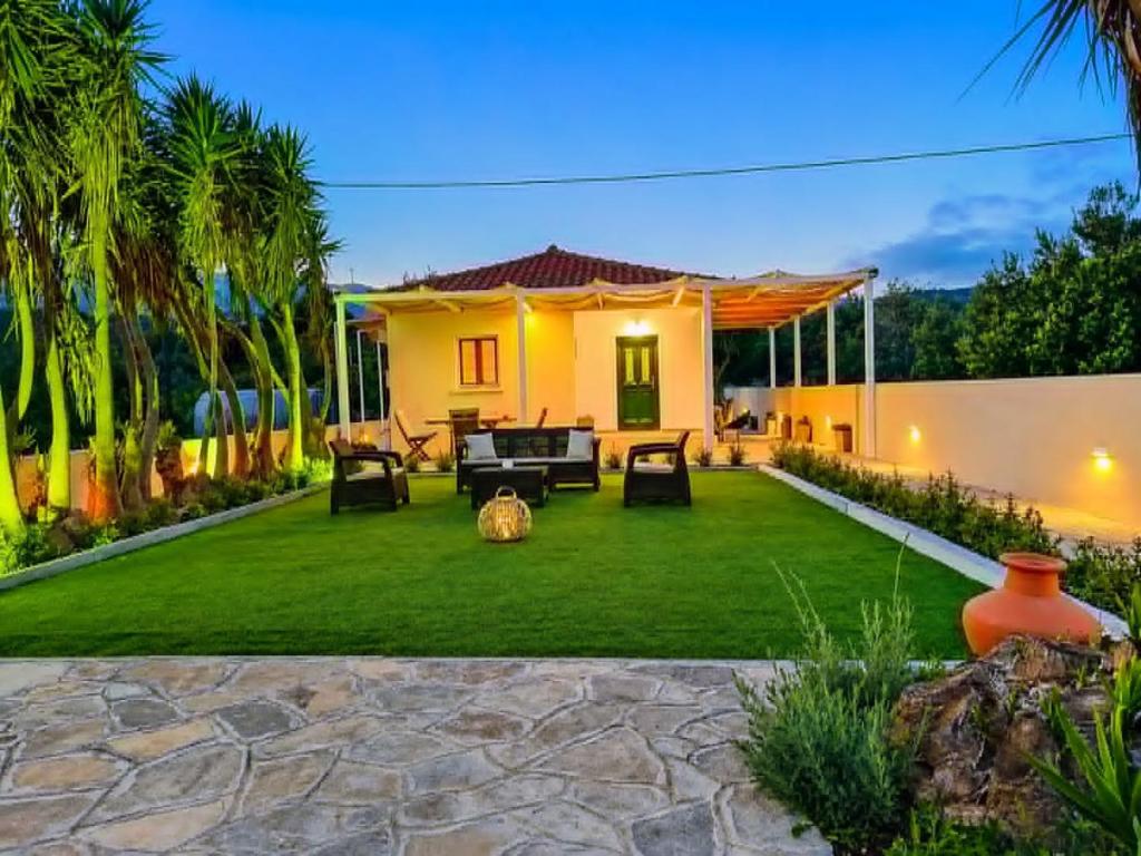 a backyard with a green lawn and a house at Ostria Beach House in Órmos Marathokámpou