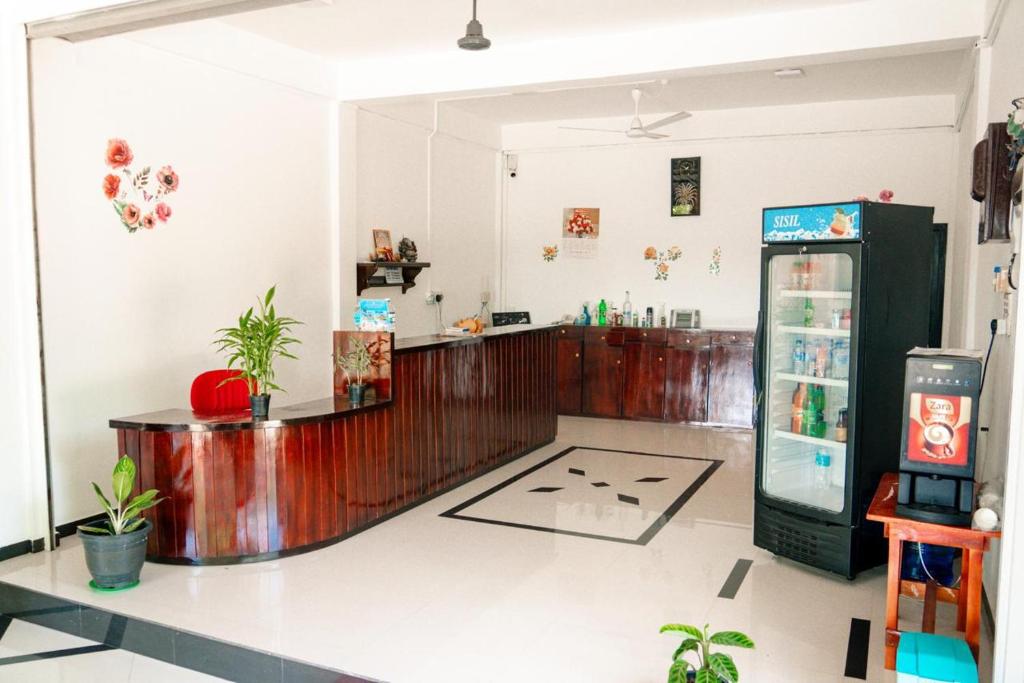 a restaurant with a drink counter and a refrigerator at Alles garden New Seaside in Trincomalee