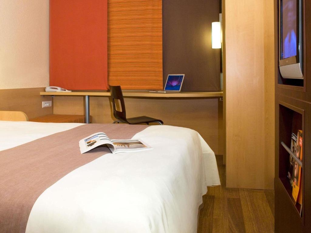 a hotel room with a bed and a tv at ibis Carlisle City Centre in Carlisle
