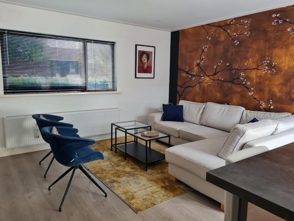 a living room with a couch and a table at Garden House Harry in Zandvoort