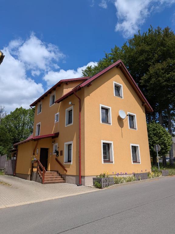 a large yellow house on the side of a street at penzion ŽEROTÍN in Staré Město