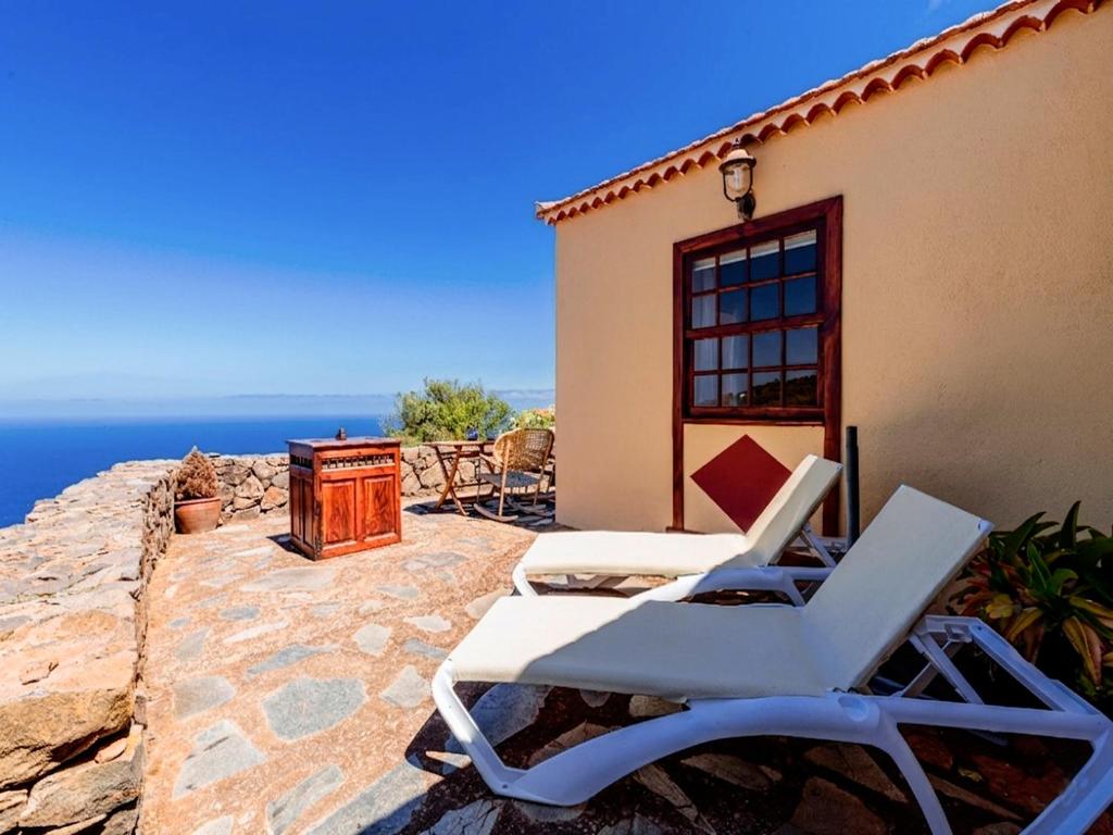a pair of lounge chairs on a patio with the ocean at Los Hondos in Garafía