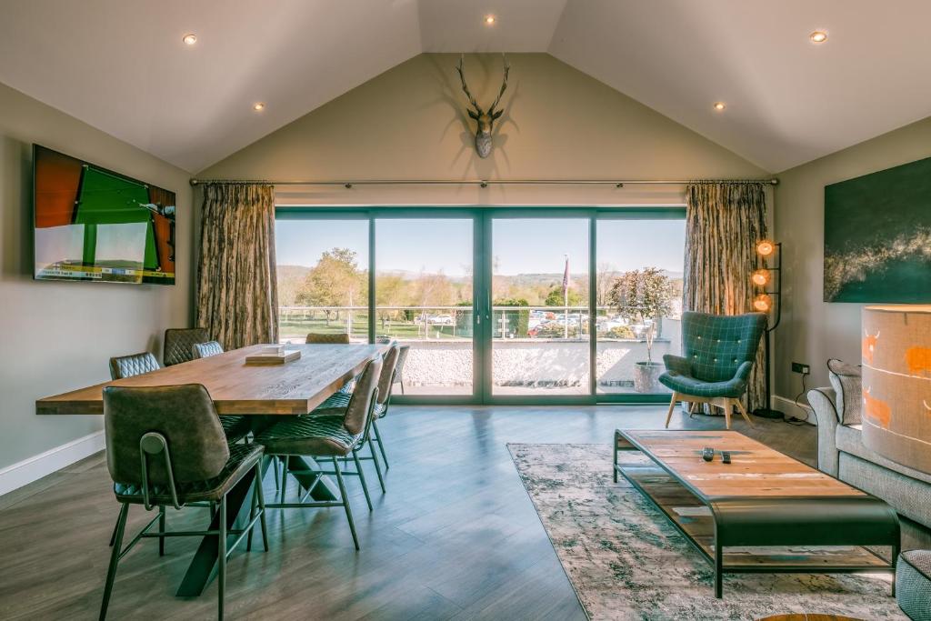 a dining room with a table and chairs and a large window at The Penthouse @ Carus Green in Kendal