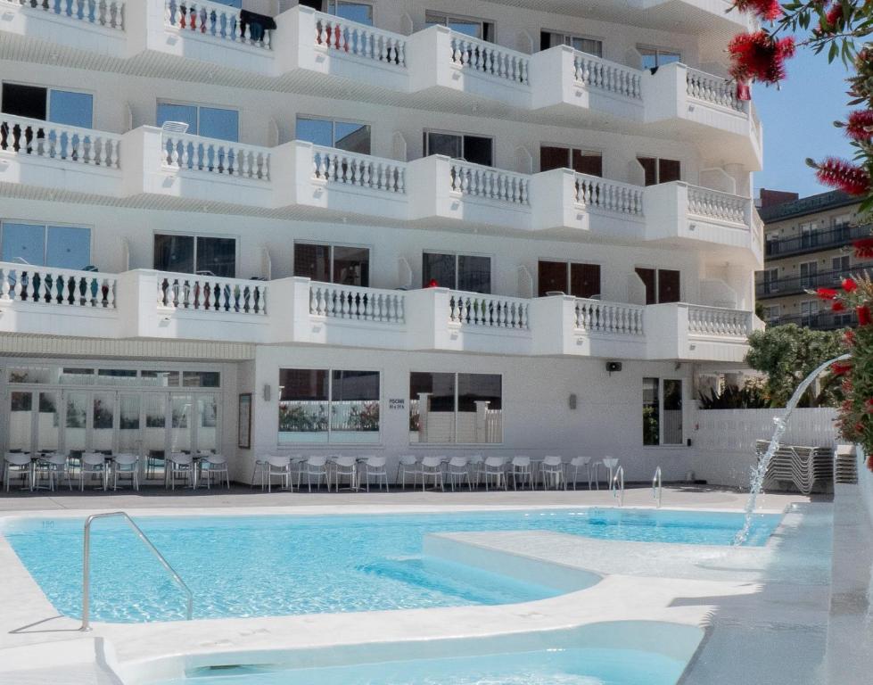 a hotel with a swimming pool in front of a building at Hotel Bernat II 4*Sup in Calella