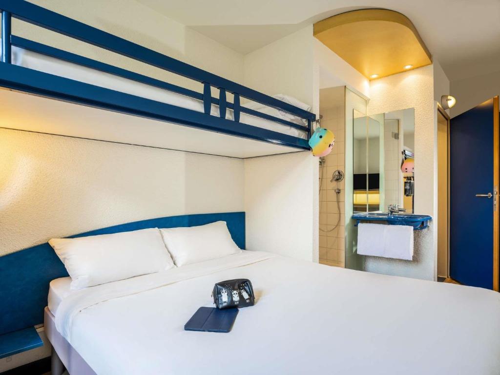a bedroom with a bed with a camera on it at Ibis Budget Graz City in Graz