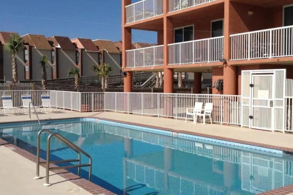 a swimming pool in front of a apartment building at Buena Vista Condominiums in Gulf Shores